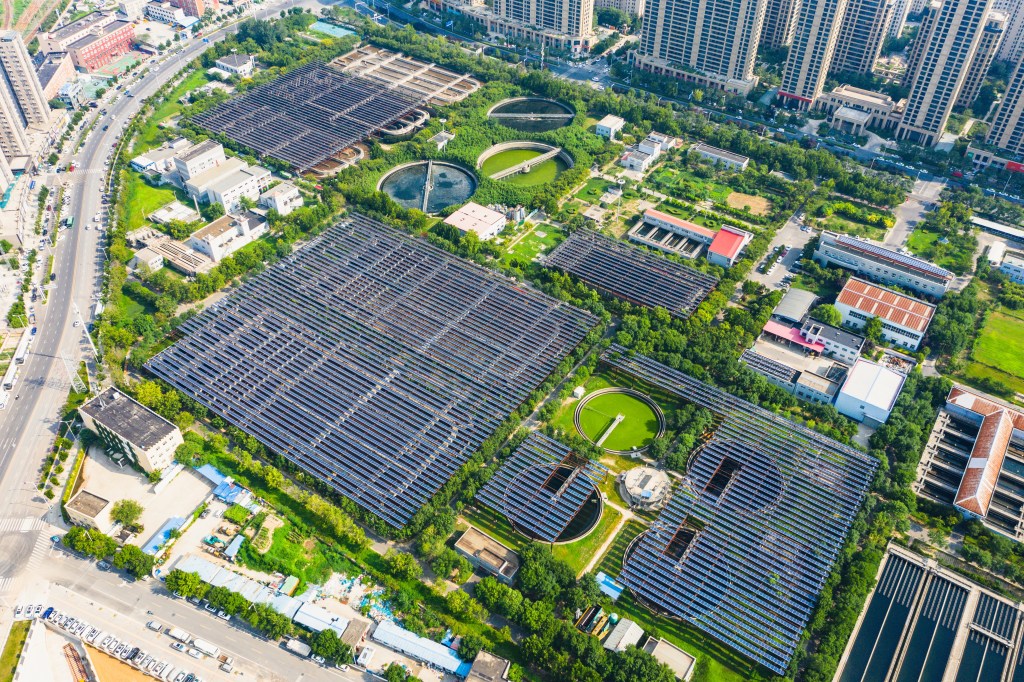 Aerial view of an urban wastewater treatment plant showing integrated green infrastructure.